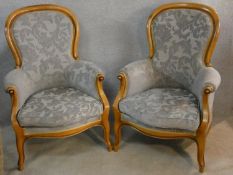 A pair of 19th century style beech framed armchairs in cut floral velour upholstery on carved