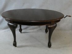 A C.1900 mahogany extending dining table with wind out mechanism and two leaves on carved cabriole