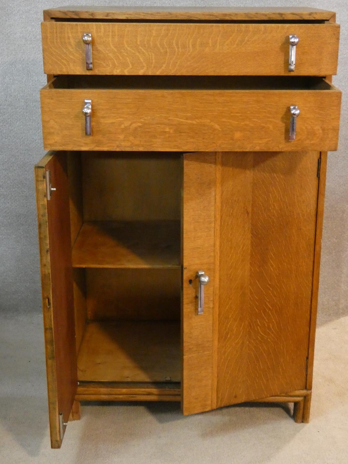 A mid century oak Art Deco style tallboy cabinet with two drawers above panel doors fitted with - Image 2 of 7