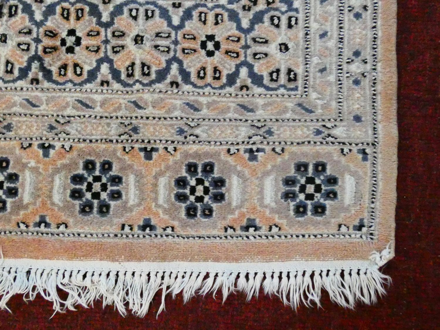 An Eastern woollen rug with repeating lozenge motifs on a beige ground within stylised multiple - Image 3 of 7