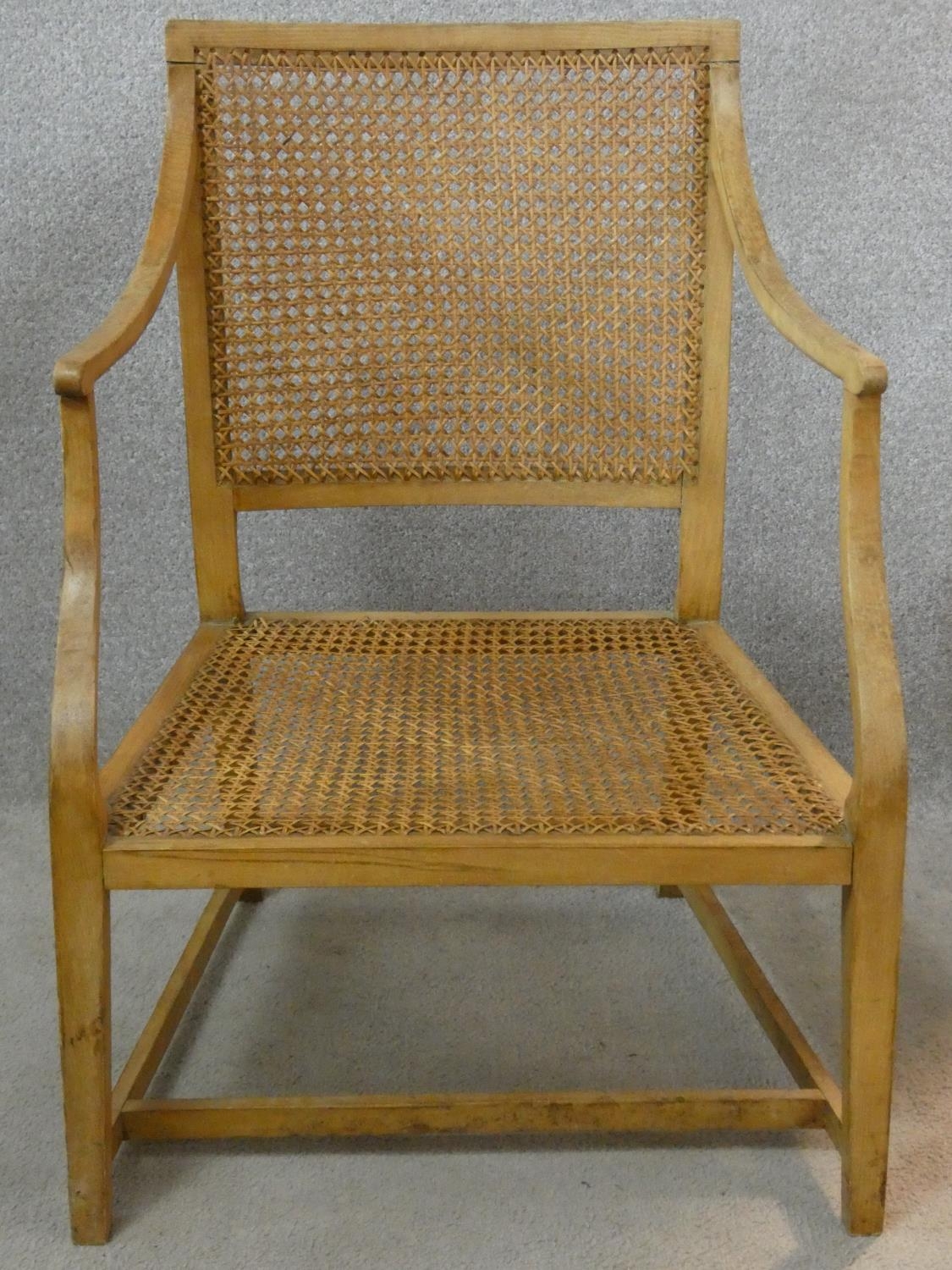 A 19th century cane library armchair with cane seat and back on square tapering stretchered