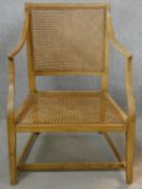 A 19th century cane library armchair with cane seat and back on square tapering stretchered