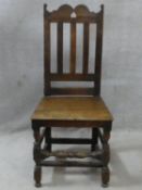 An antique oak hall chair with shaped and pierced rail back above panel seat on turned and