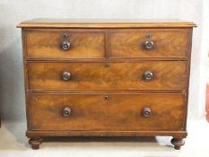 A 19th century mahogany chest of two short over three long drawers with knob handles on turned feet.