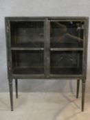 A contemporary vintage industrial style metal display cabinet or bookcase on tapering supports. H.