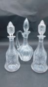 Three antique cut and engraved blown glass decanters. A pair with engraved vine design and bell