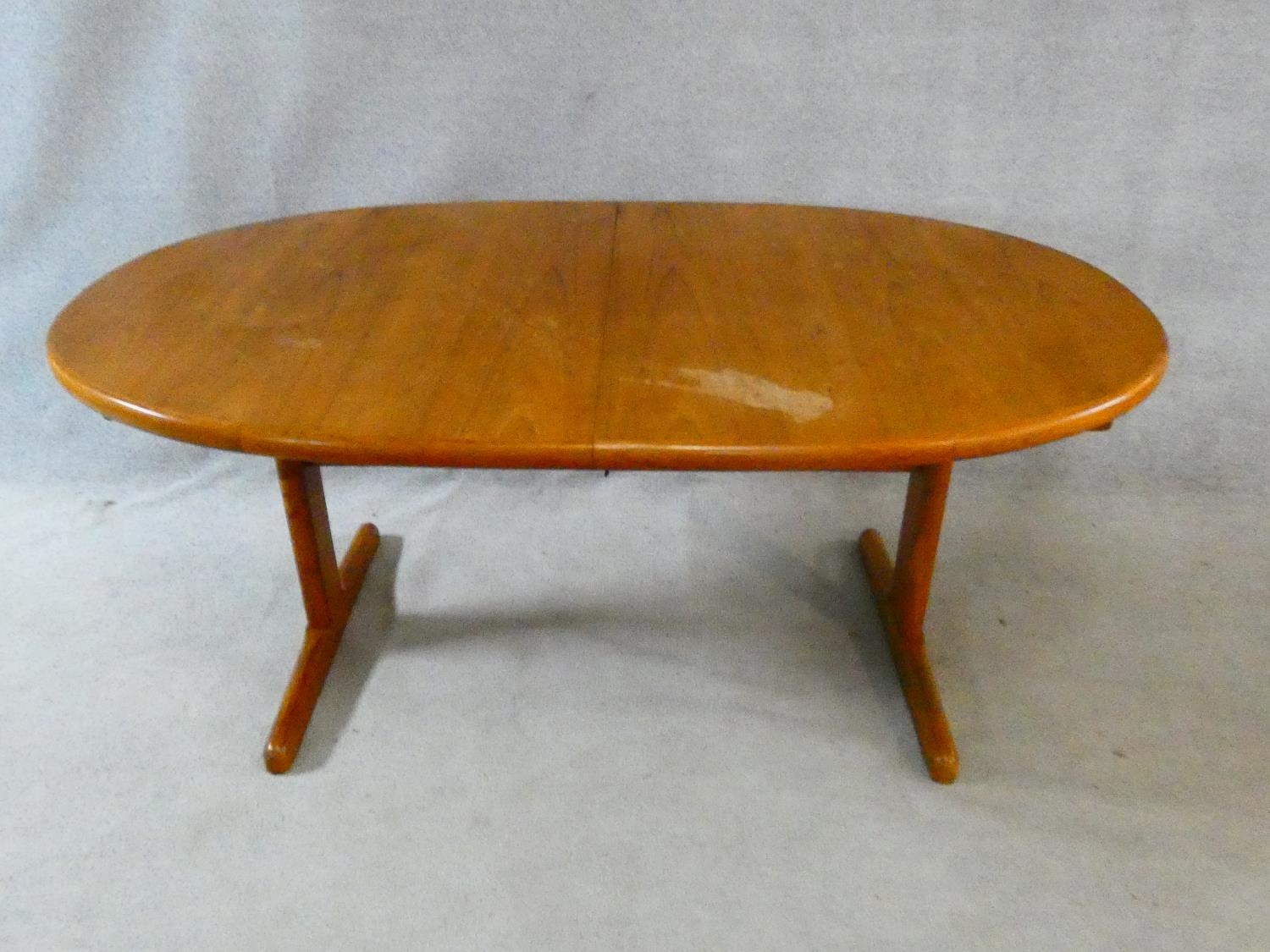 A 1960's vintage teak extending dining table on trestle style supports with extra leaf. H.72 L.167