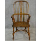 A 19th century elm Windsor armchair with pierced splat above moulded seat on turned supports