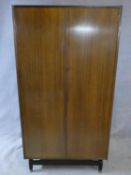 A mid century vintage teak G-Plan fitted compactum wardrobe on ebonised feet with Ebenezer Gomme