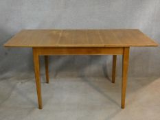 A mid century vintage teak dining table with extra leaf on square tapering supports. H.76 L.154 W.