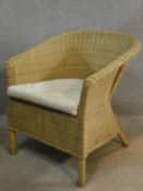 A wicker Lloyd Loom style conservatory tub armchair fitted with squab cushion. H.76cm