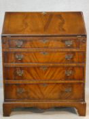 A Georgian style flame mahogany bureau with fitted interior and four long graduating drawers on