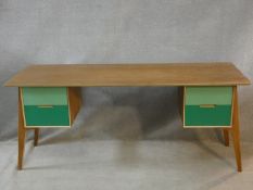 A vintage style teak writing desk with painted drawers to the kneehole section on splay supports.