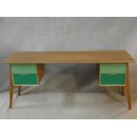 A vintage style teak writing desk with painted drawers to the kneehole section on splay supports.