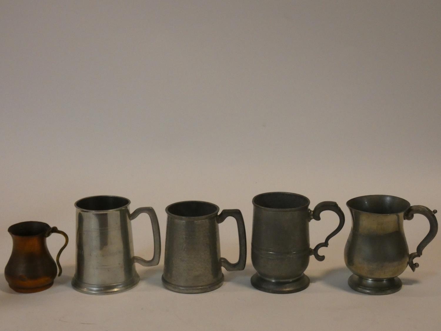 A miscellaneous collection of five 19th century and later pewter and copper tankards. H.13cm