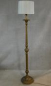 A mid century carved and gilt standard lamp with spiral twist and fluted column on platform base.