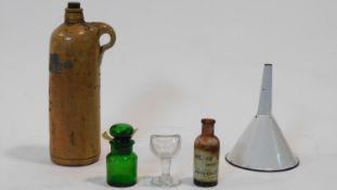 A collection of antique pharmaceutical items. Including a clear glass stemmed eye bath, a white