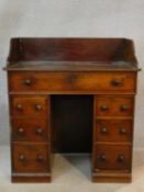 A mid 19th century mahogany kneehole desk with raised superstructure above an arrangement of drawers