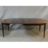 A Danish rosewood extending dining table with two extra leaves on square tapering supports. H.73 L.