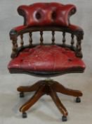 A 19th century style mahogany framed captain's revolving desk chair in buttoned leather