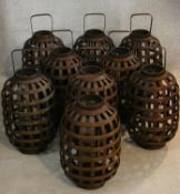 Nine Chinese style storm lanterns in wicker cases with carrying handles. H.46cm