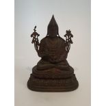 An antique Tibetan bronze buddha statue sitting on a lotus flower. H.26xW.18.5cm