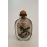 A Chinese reverse painted glass snuff bottle decorated with horses and Chinese character marks, with