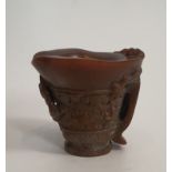 An antique Chinese carved libation cup. Decorated with figures and foliage with a two strand handle.