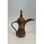 A large Islamic Arabic Dallah copper coffee pot with hammered design. H.43x38cm