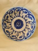 A 17th century Safavid Fritware blue and white ceramic plate, decorated with a stylized spiral