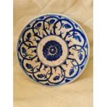 A 17th century Safavid Fritware blue and white ceramic plate, decorated with a stylized spiral