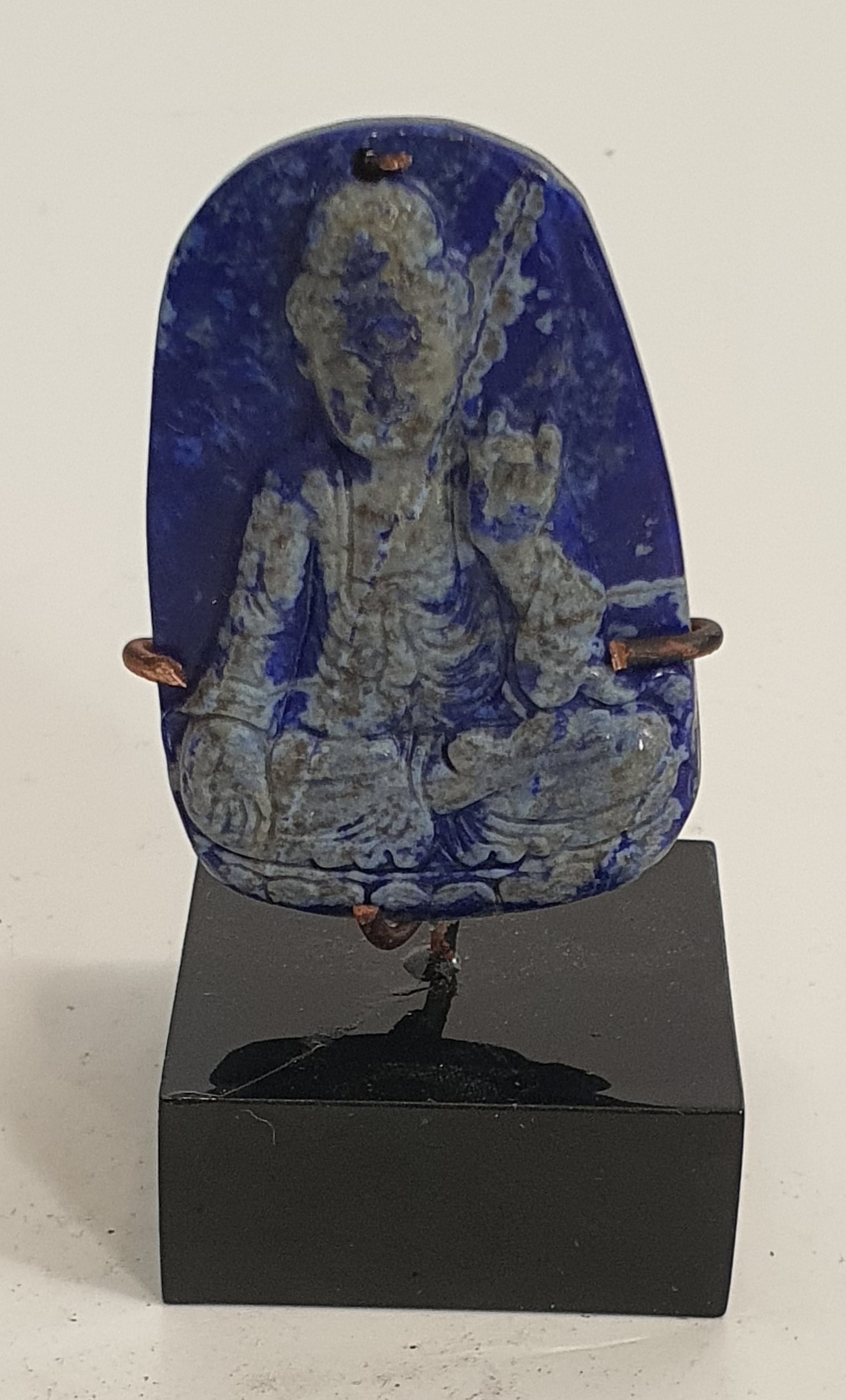 A Chinese Lapis Lazuli pendant carved with a Buddha. Mounted on a metal display stand. H.5.5cm - Image 2 of 3