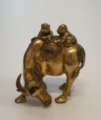 An antique Chinese gilded bronze statue of a water buffalo with two men climbing on its back, one