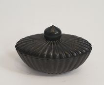 An oval Chinese green stone lidded bowl with a gadrooned design and tear drop finial. H.12xW.8cm