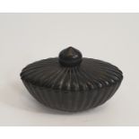 An oval Chinese green stone lidded bowl with a gadrooned design and tear drop finial. H.12xW.8cm