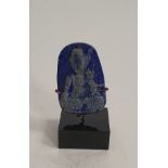 A Chinese Lapis Lazuli pendant carved with a Buddha. Mounted on a metal display stand. H.5.5cm