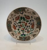 An 17th or 18th century Turkish Iznik hand painted glazed ceramic plate, decorated with a stylised