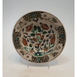 An 17th or 18th century Turkish Iznik hand painted glazed ceramic plate, decorated with a stylised