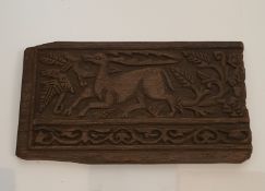 A Fatimid Islamic carved wooden plaque, depicting a stylized deer among foliage with a scrolling