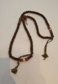 A string of Tibetan wooden, coral and turquoise prayer beads, with brass bead decoration. H.45cm