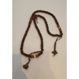 A string of Tibetan wooden, coral and turquoise prayer beads, with brass bead decoration. H.45cm