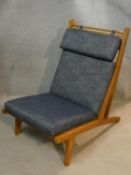 After Hans J Wegner, a mid century light oak reclining easy chair with removable cushions. H.94