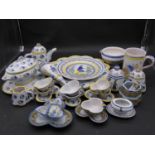 A large collection of antique Adolphe Porquier Quimper hand painted pottery dinner ware. Decorated