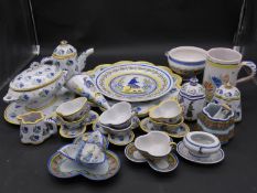 A large collection of antique Adolphe Porquier Quimper hand painted pottery dinner ware. Decorated