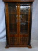 A contemporary burr walnut lacquered finished display cabinet with glazed doors flanked by