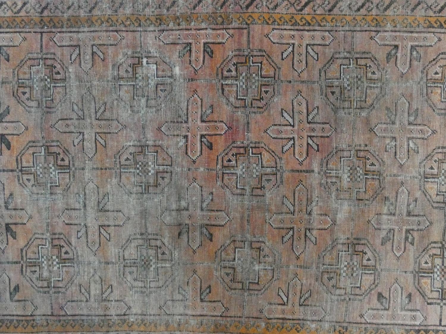 An Eastern rug with repeating gul motifs across the madder field within highly stylised foliate - Image 2 of 5