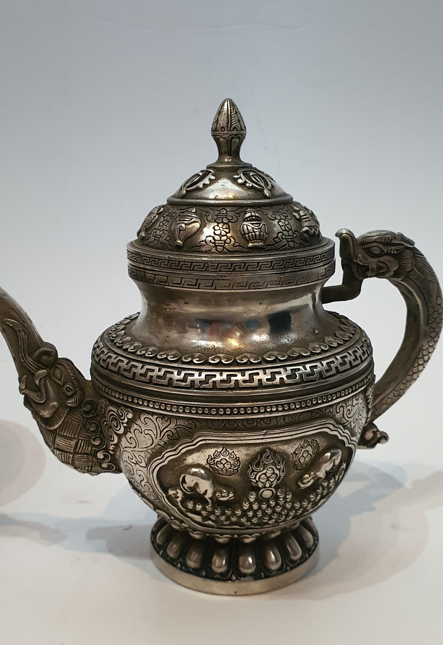 A pair of Chinese Tibetan white metal repousse design wine jugs. Decorated with animals, symbols and - Image 2 of 5