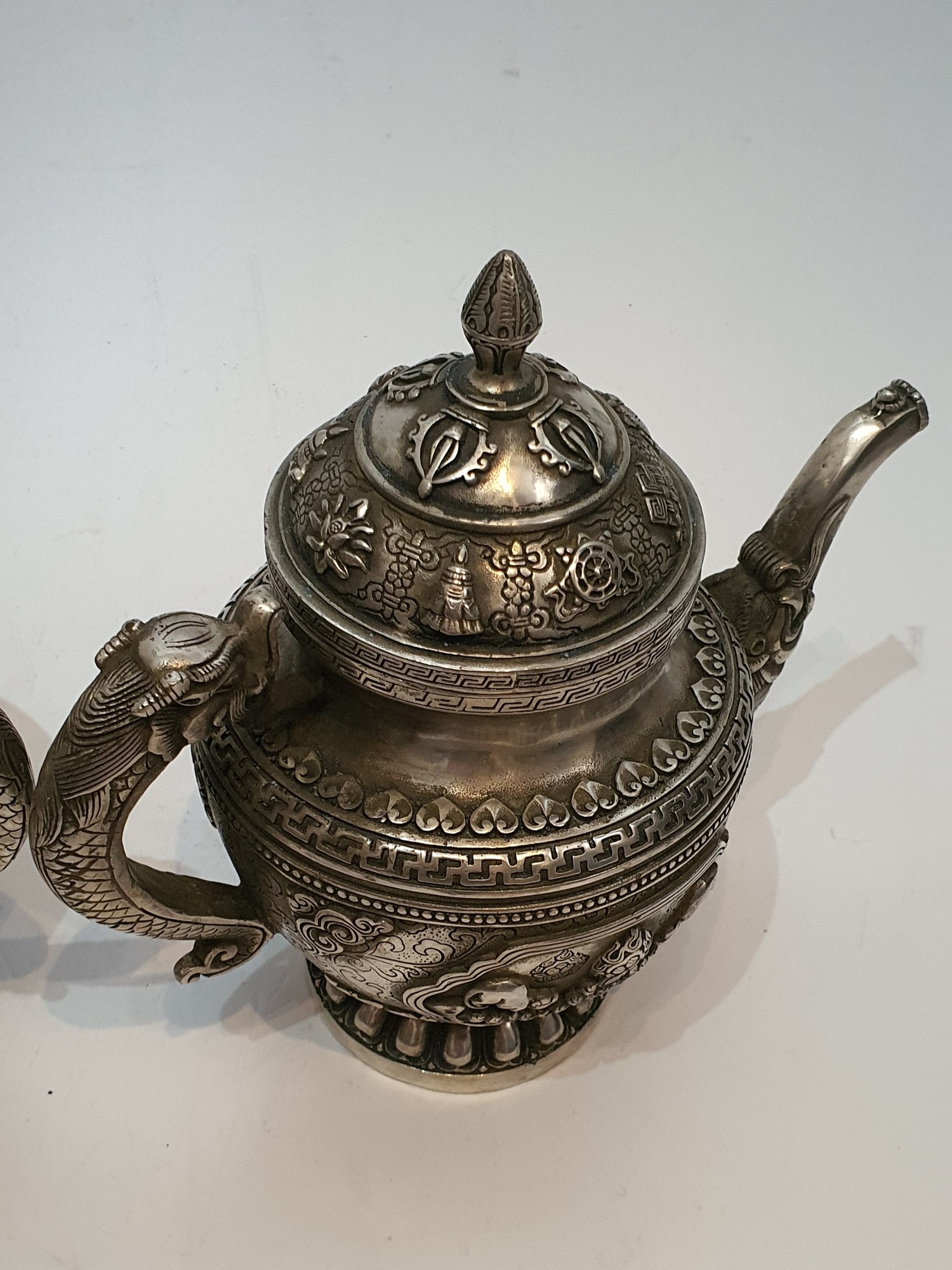 A pair of Chinese Tibetan white metal repousse design wine jugs. Decorated with animals, symbols and - Image 5 of 5