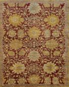 A Ziegler style carpet with repeating meandering vine and palmette design on a deep burgundy