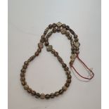 A Chinese Pumtek bead necklace, made from fossilized palm wood with a Batik design. L59cm/118cm.